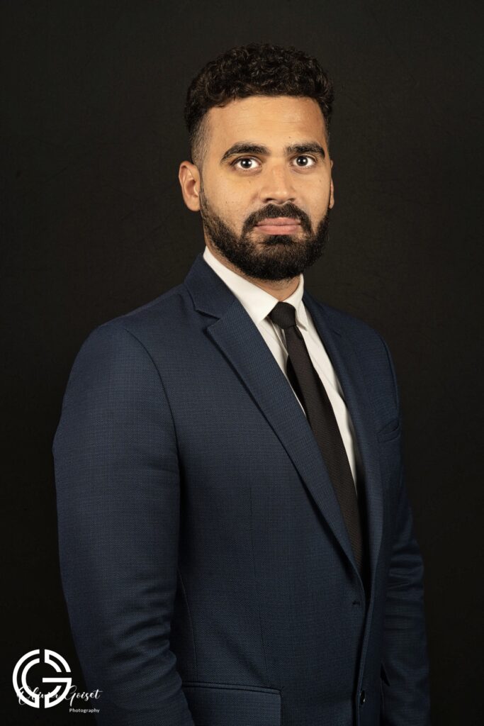 Portrait corporate en studio sur fond sombre, costume bleu nuit — réalisé par Olivier Goiset.